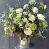 A serene and elegant garden arrangement featuring soft cream and white blooms