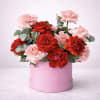 Pink and red roses arranged in a round pink box