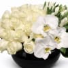 Arrangement white roses, orchids and white tulips. Changes can be made.