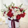 Box hat flowers with red and white roses, spray roses and lisianthus.