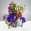 This arrangement is inside a basket, with seasonal flowers and vibrant colors