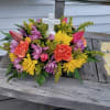 Table centerpiece filled with tulips, daisies, carnations and more with a keepsake