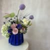 Set in a stunning blue vessel, this lavender, pink and white composition
