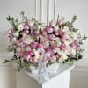 Large pink and white rose arrangement in a white vase