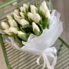 Fresh white tulips wrapped in elegant floral paper and finished with a