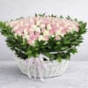 Pink and white roses in a white wicker basket with a ribbon