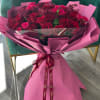 Bouquet of red roses wrapped in pink paper with a ribbon