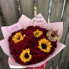 Bouquet of red roses and yellow sunflowers wrapped in pink paper