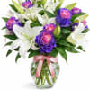 A stunning blend of elegant white lilies and vibrant purple-pink roses, beautifully