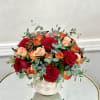 Bouquet of red and peach roses in a white vase