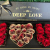 Heart-shaped rose box with red and cream roses in a black gift box