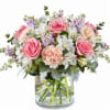 Pink roses and peach carnations in a clear glass vase