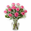 Pink roses arranged in a clear glass vase with white filler flowers
