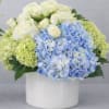 Blue and white flower arrangement in a white vase