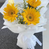 Bright sunflower bouquet wrapped in elegant white paper with delicate baby&rsquo;s breath.