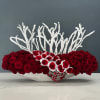 Low arrangement of red roses with white accents in a shallow bowl