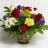 Basket arrangement of red roses, daisies, carnations, and purple filler flowers