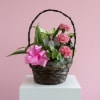 A medium-sized garden basket featuring fresh pink carnations and a wildflower butterfly