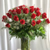 Red roses arranged in a clear glass vase