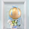 Baby gift basket with flowers, teddy bear, and gold balloon