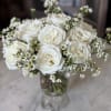A dozen Playa Blanca white roses with wax flower accent in a