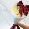 A refined and elegant bouquet featuring soft white blooms beautifully wrapped in