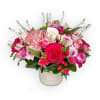 Medium arrangement filled with spring blooms in a concrete vase. 