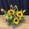 Bright sunflowers and cheerful tulips come together in this warm, garden-inspired basket