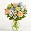 Peach roses and white daisies in a clear glass vase