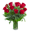Red roses arranged in a clear glass vase with greenery