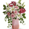 Pink and white floral arrangement in a tall pink vase