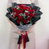A luxurious bouquet of premium red roses beautifully arranged with lush greenery