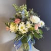 This beautiful flower arrangement of fresh mixed seasonal blooms is made by