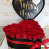 Heart-shaped box of red roses with a black 