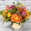 A warm sunset palette arranged skillfully in a ceramic vase. Featuring yellows
