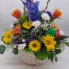 Wicker handled basket filled with Tulips, yellow daisies, delphinium, and other fresh