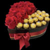 A heart box shape with some red roses and Ferrero Rocher chocolates