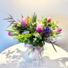 A graceful spring arrangement featuring Tulips and fragrant Hyacinth, lush seasonal greens
