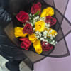 Bouquet of red and yellow roses with white baby's breath in black wrap