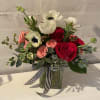 Bouquet of red and blush roses with white anemones in a glass vase