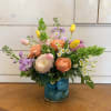 A bright spring arrangement of pink and yellow tulips, and apricot roses