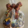 Gift basket of assorted packaged foods wrapped in cellophane with a plaid bow