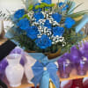 Blue roses with white baby's breath in a wrapped bouquet