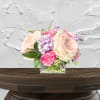 Pink and cream roses with lavender flowers in a glass vase