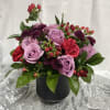 Deep purples are contrasted with sweet purple roses and accents of red