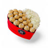 A luxurious heart box featuring creamy white roses paired with decadent Ferrero