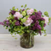 This floral arrangement is a beautiful combination of purple lilacs and pink