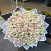 Large bouquet of pale pink and green roses wrapped in white paper