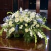 Beside the River is an elegant white and blue casket spray designed