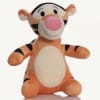 Plush Tigger stuffed animal sitting upright on a white background